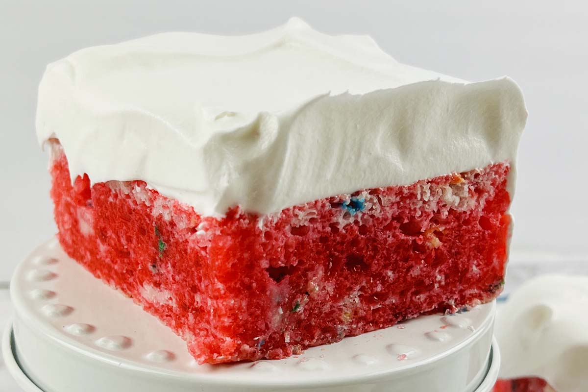 A slice of cake on a white plate.