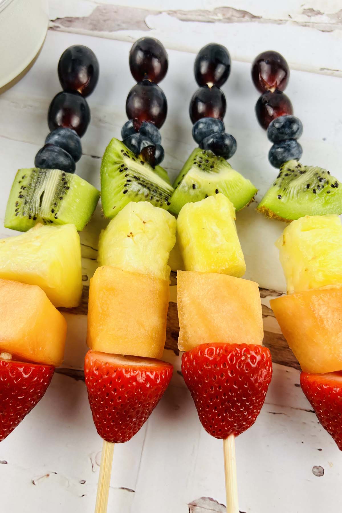 Four assembled fruit skewers.