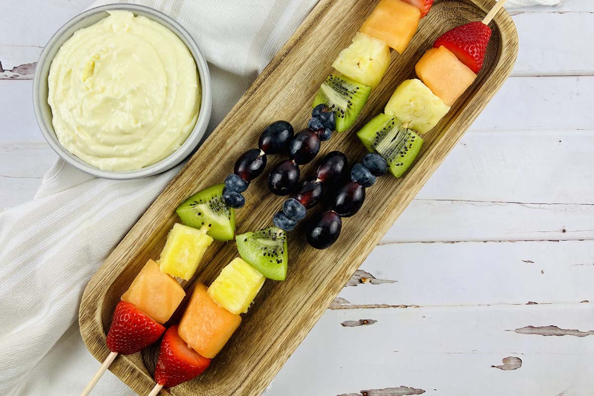 Fruit skewers on a wood platter.