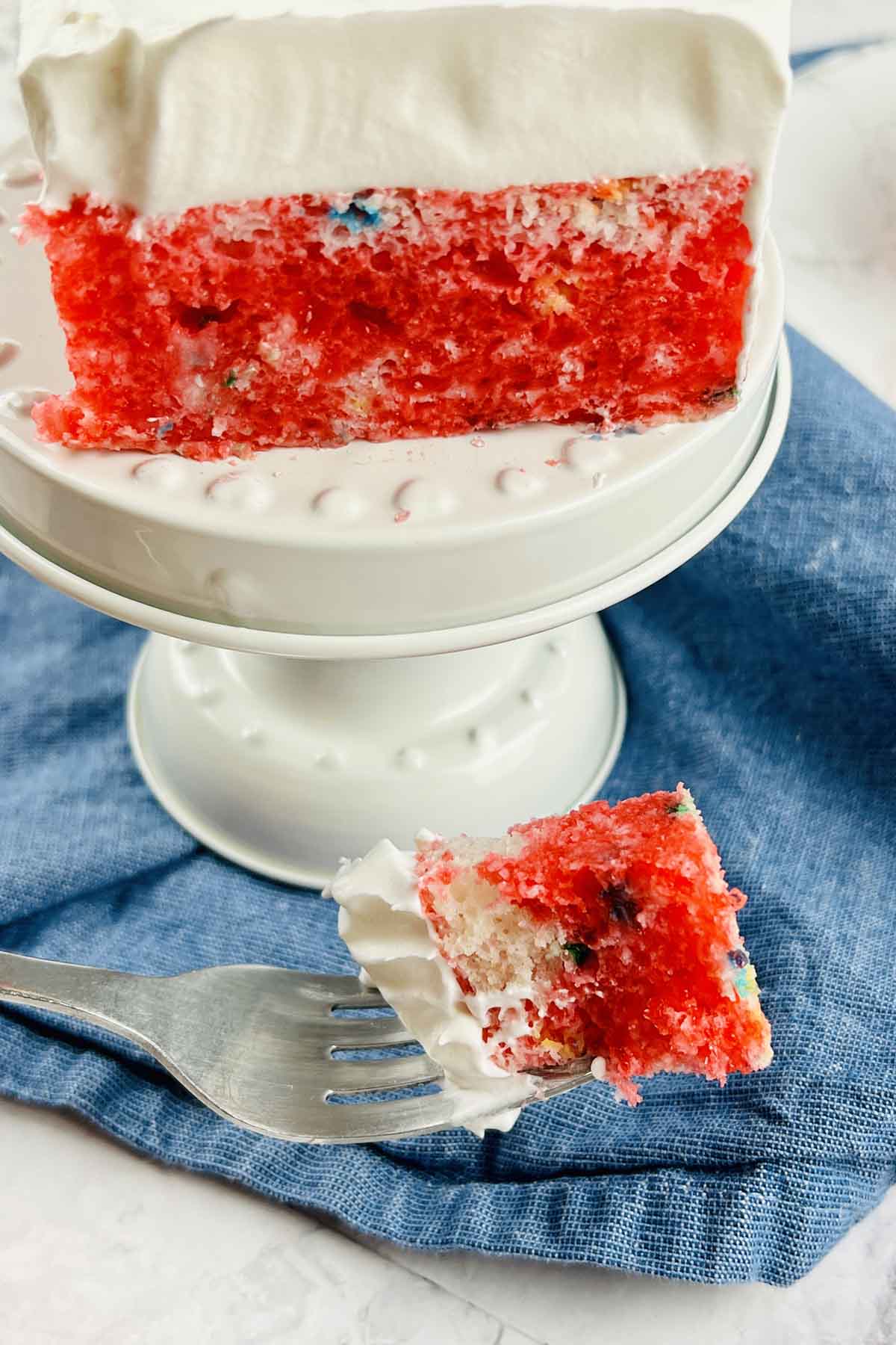 piece of cake on a fork in front of cake slice.