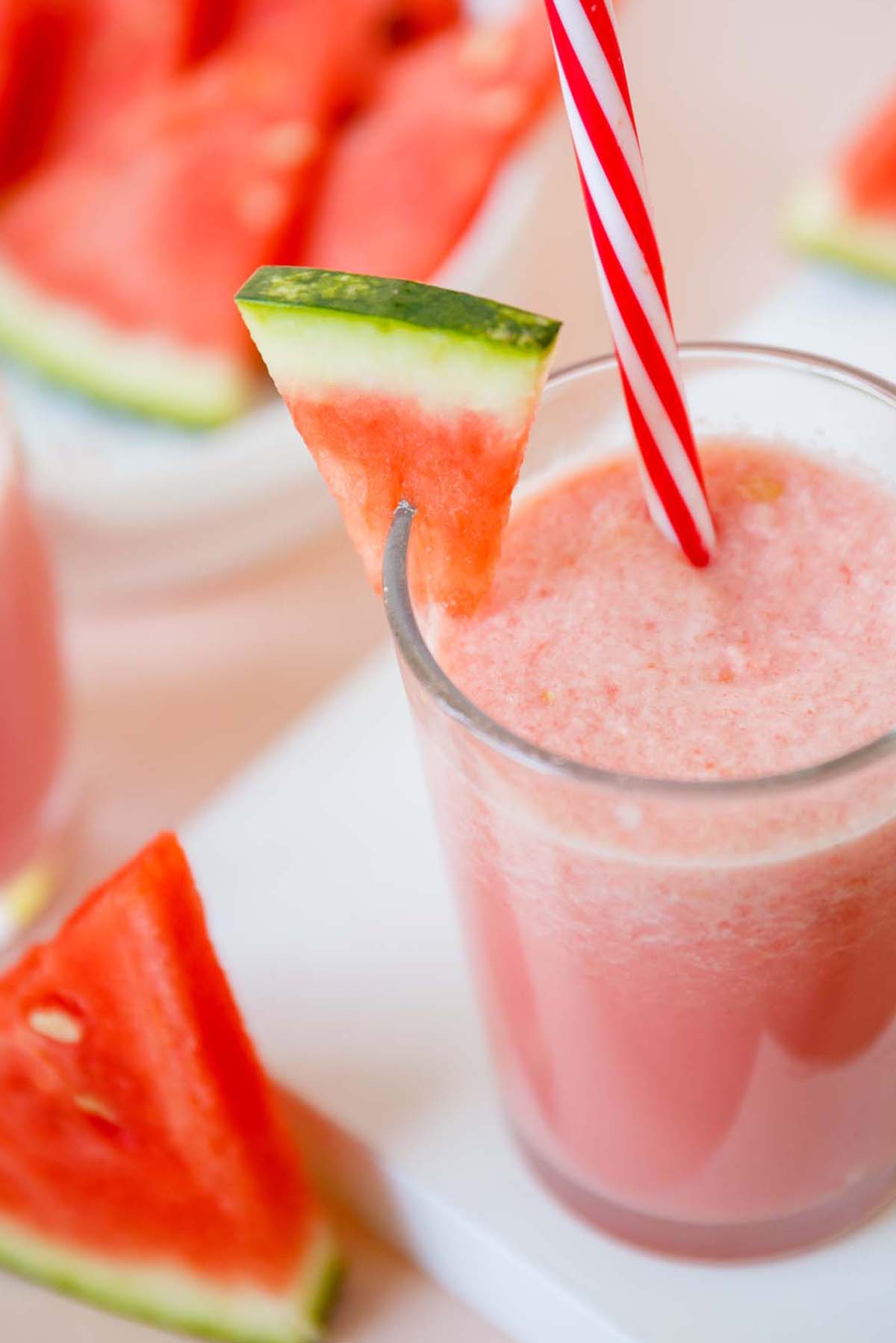 Drink with a straw and a watermelon wedge on the glass.