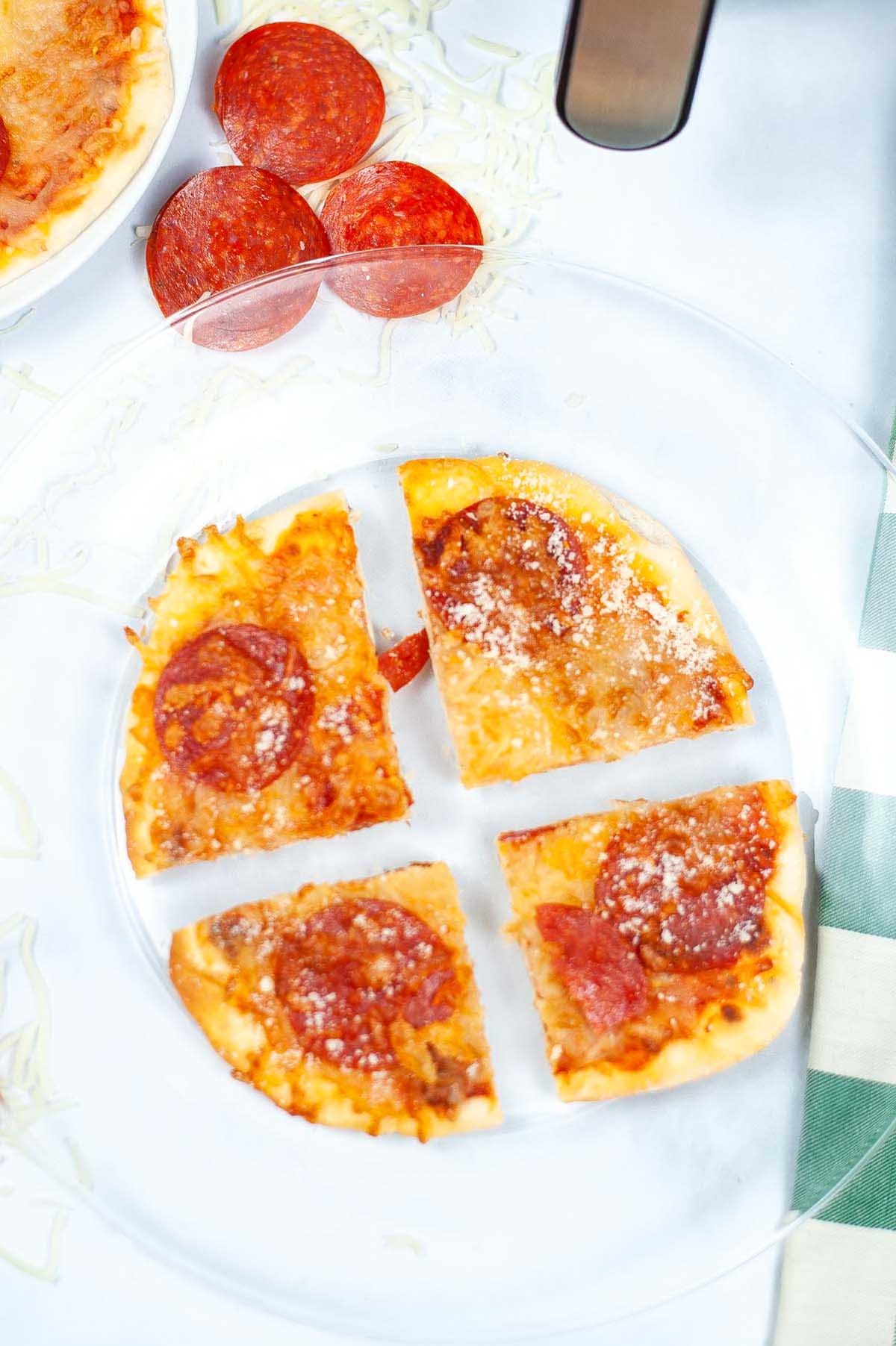 Pepperoni pizza on a clear plate.