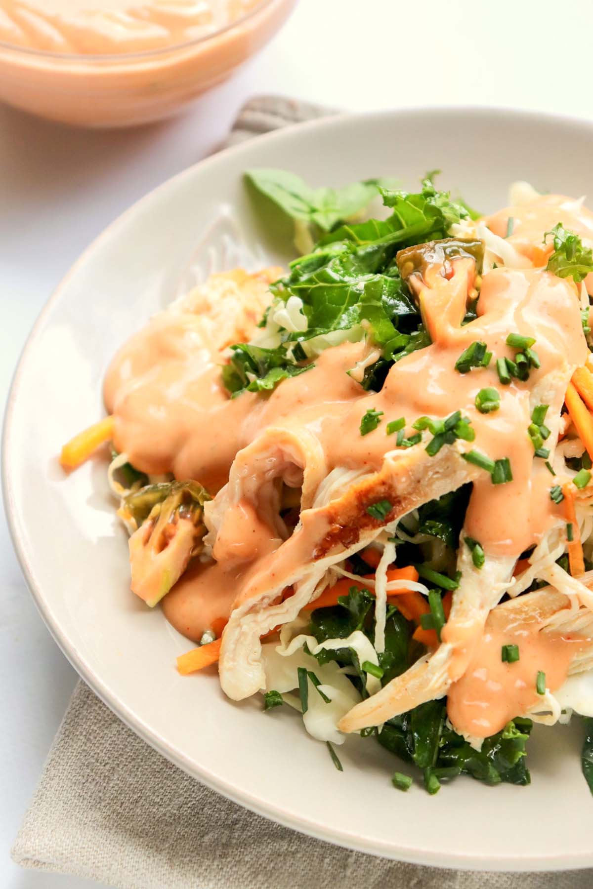 dressing drizzled over a bowl of salad.