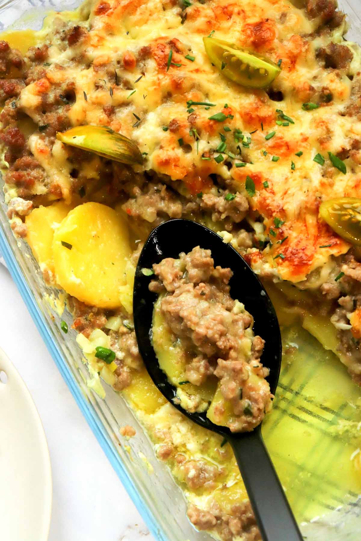 spoon scooping casserole from baking dish.