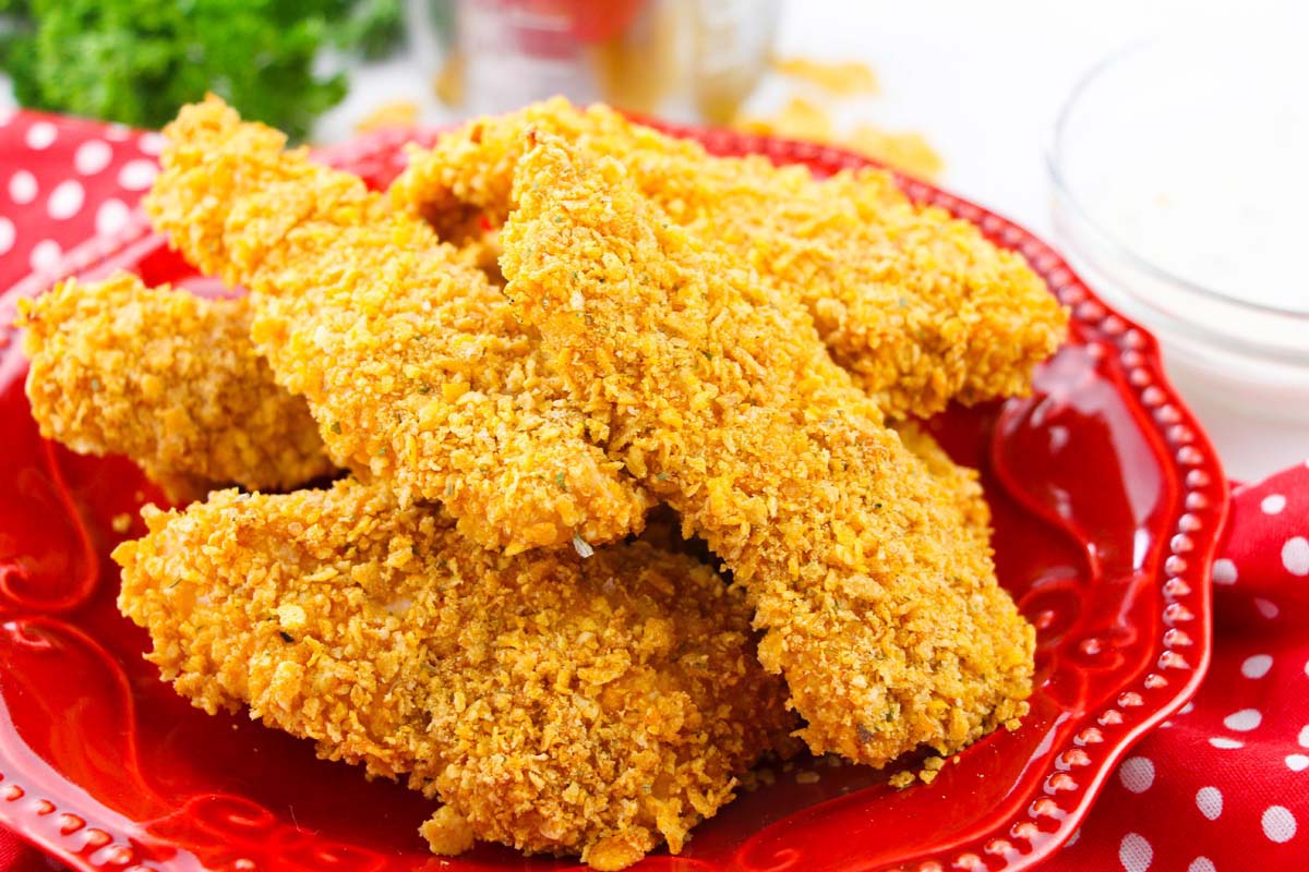 Chicken tenders piled on a plate.