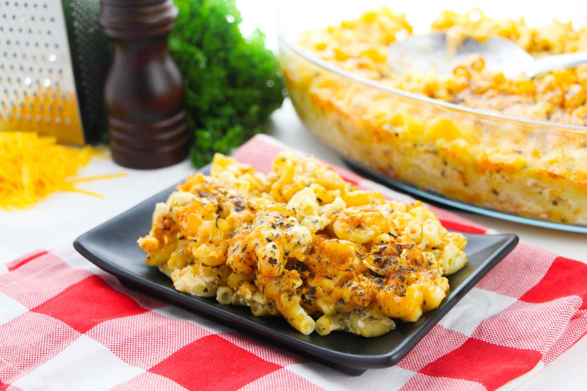 Mac and cheese on a black plate and in a serving dish.