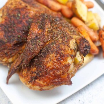 top view of half chicken on a plate with vegetables.