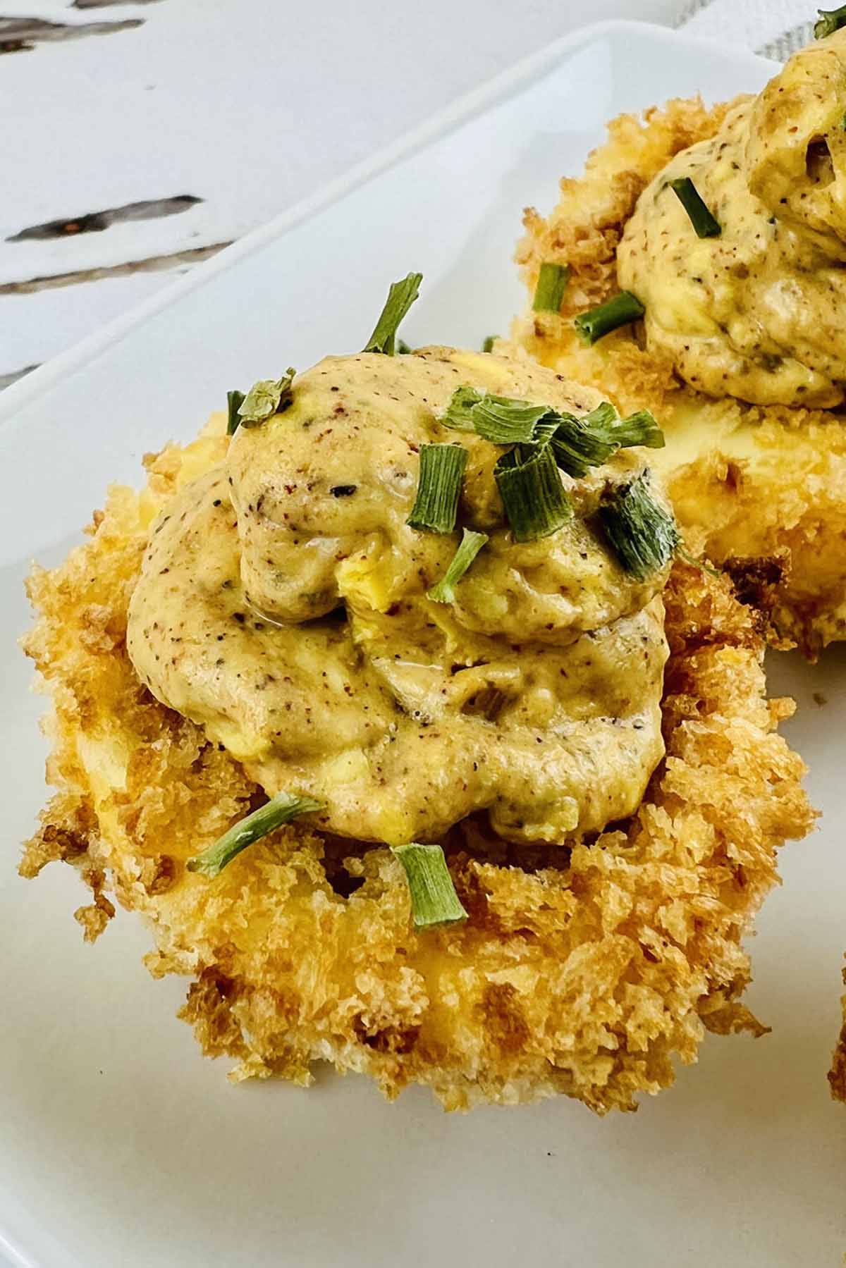 Deviled egg topped with green onion slices.