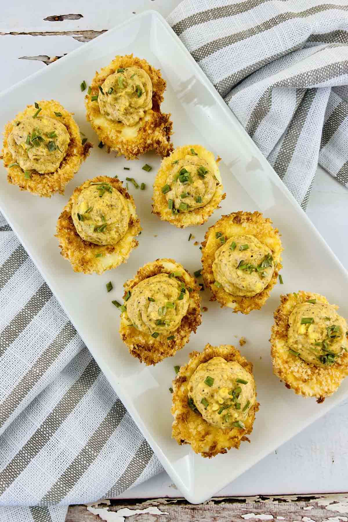 Deviled eggs on a white serving platter.