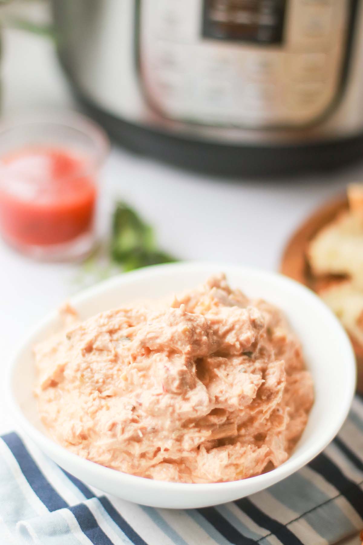 Bowl of chicken dip set on a towel.