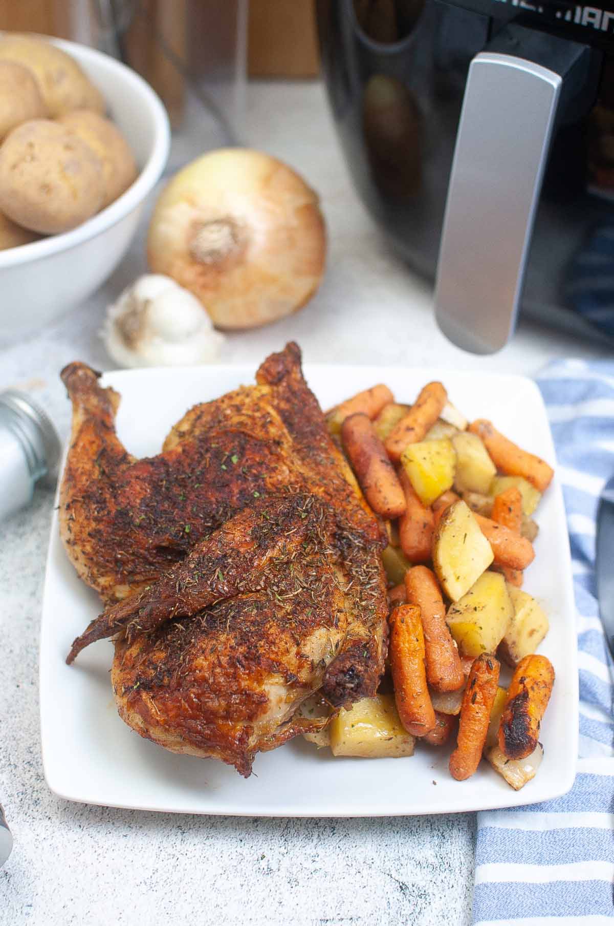 Chicken and vegetables on a white plate.