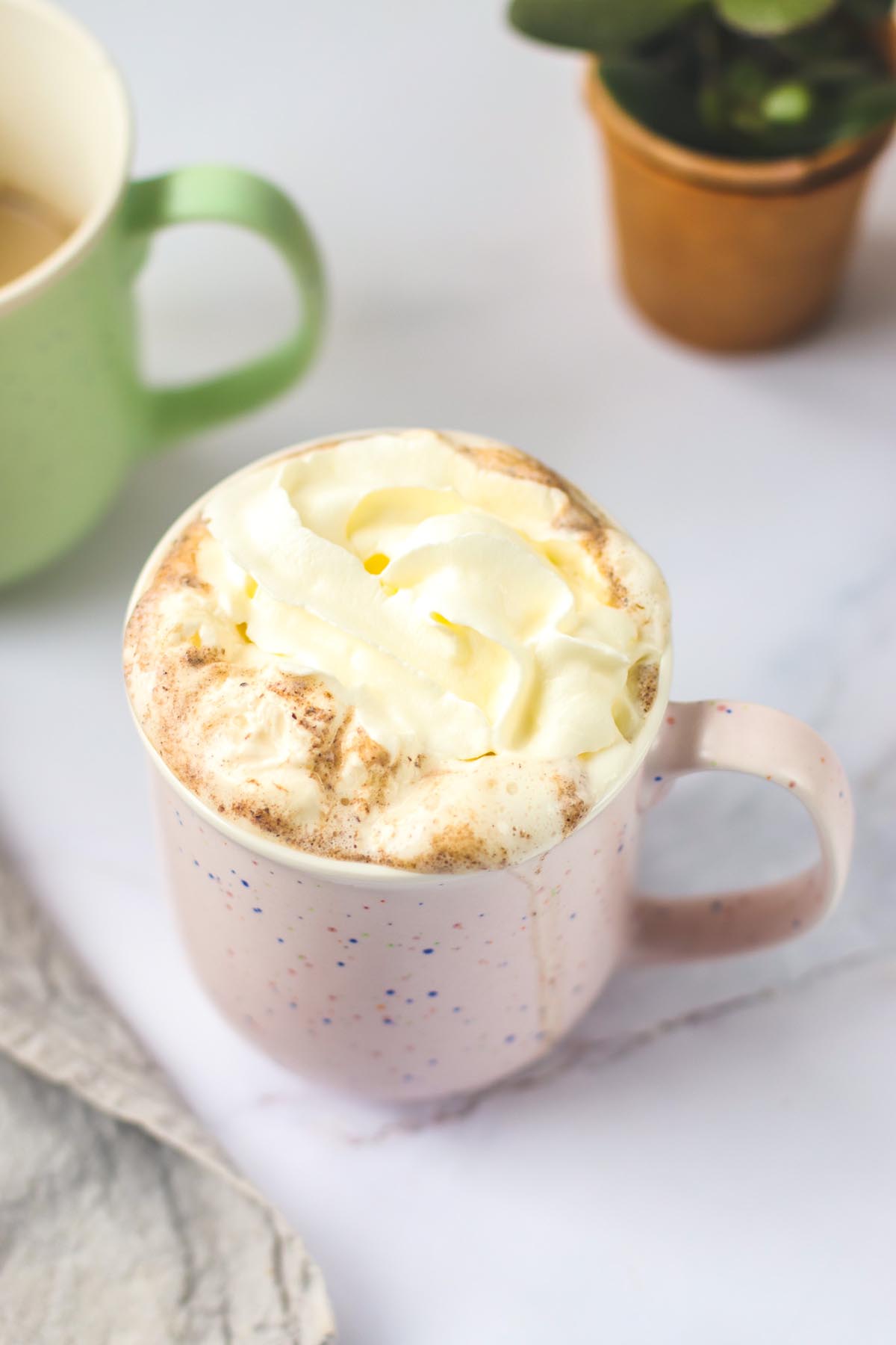 top view pink mug with whipped cream on top.