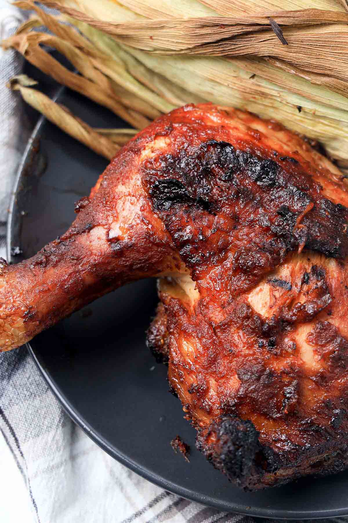 Crispy bbq chicken on a black plate.