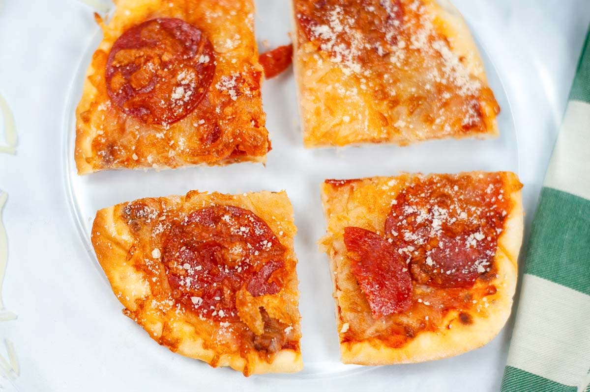 Pepperoni pizza on a clear plate.