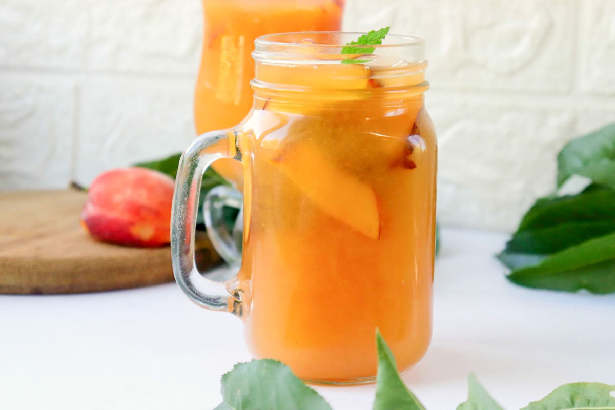 Iced tea in a jar topped with a sprig of mint.