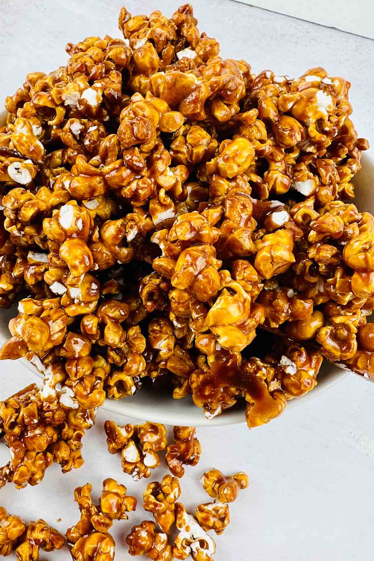 Caramel popcorn spilling out of a bowl.