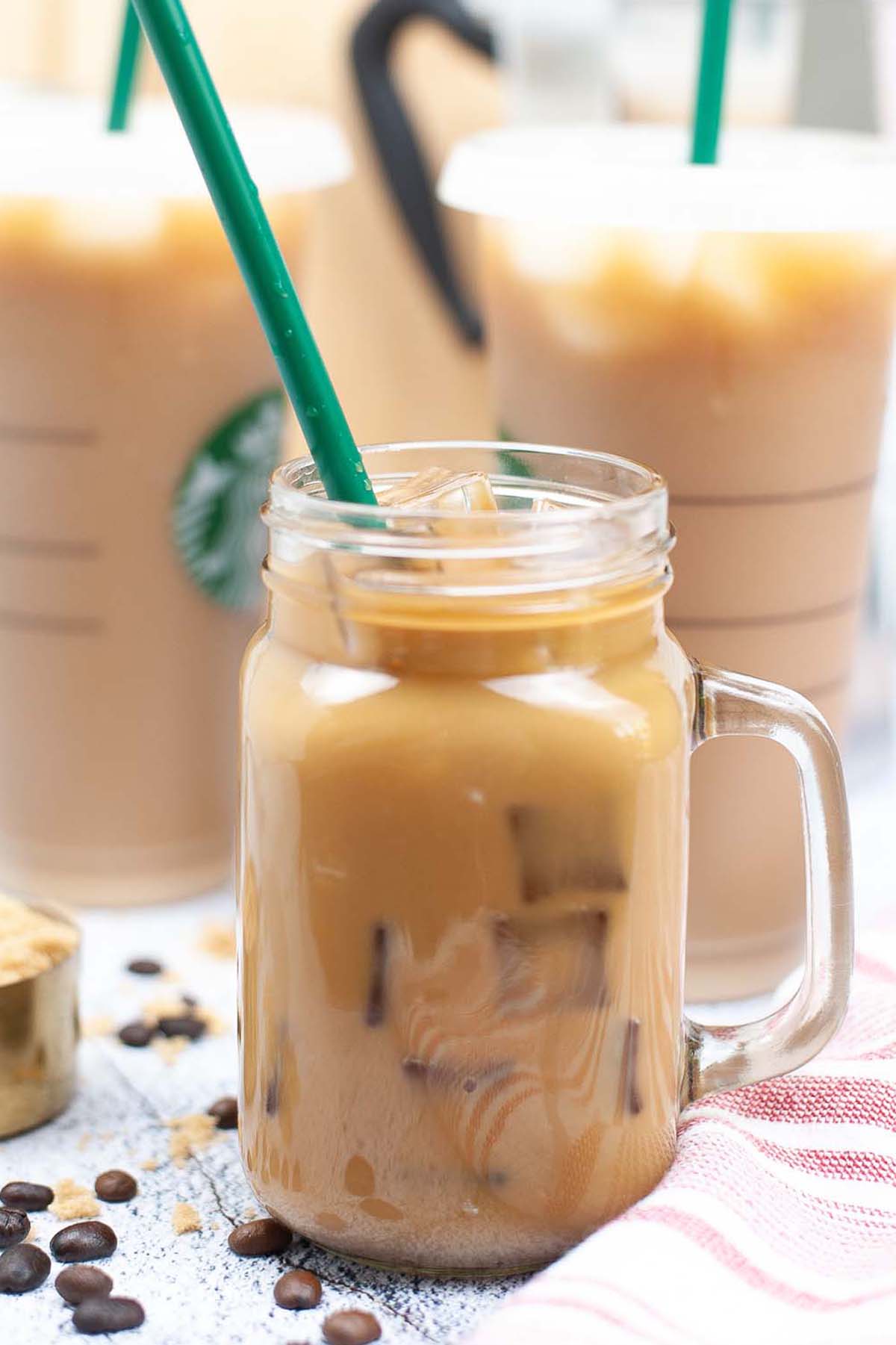 Iced coffee in a jar with a green straw.