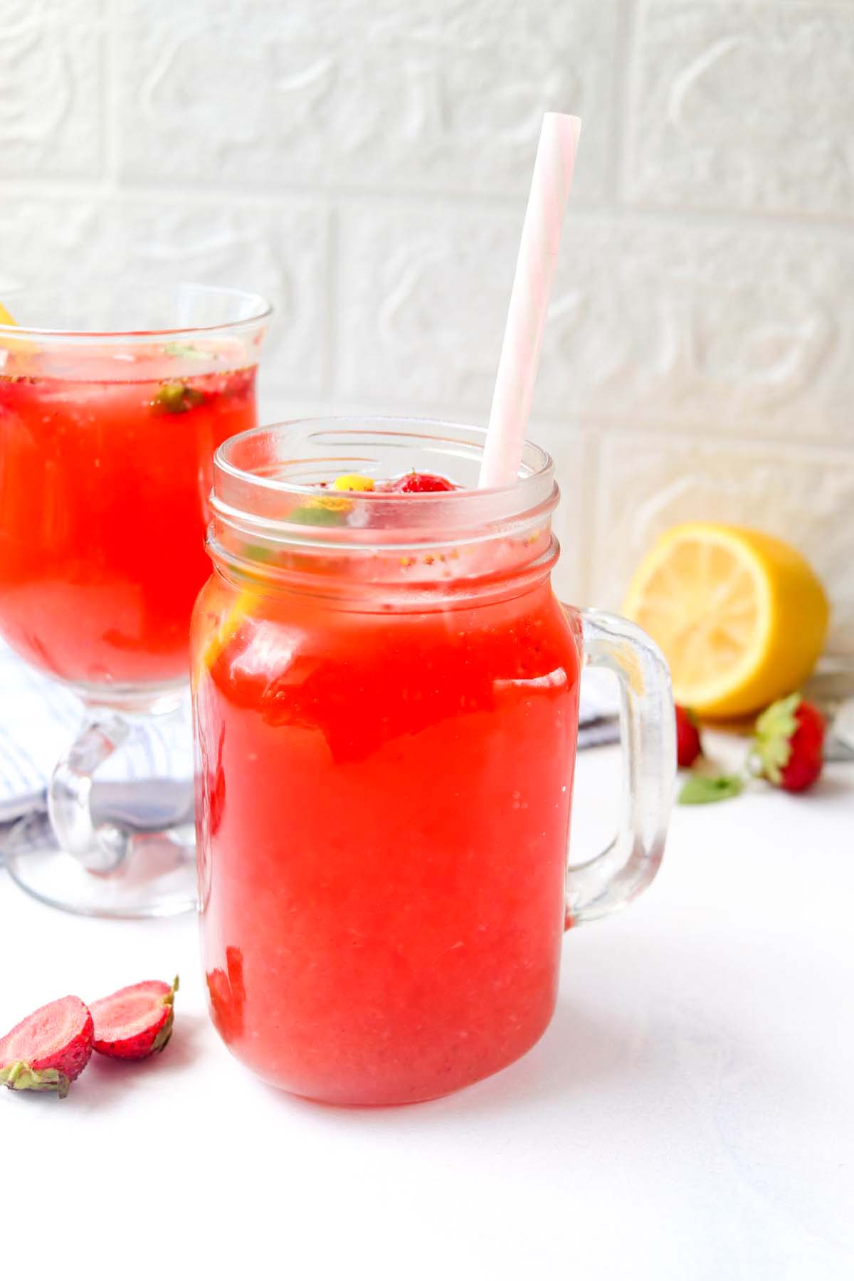 Strawberry lemonade in a glass with a straw.