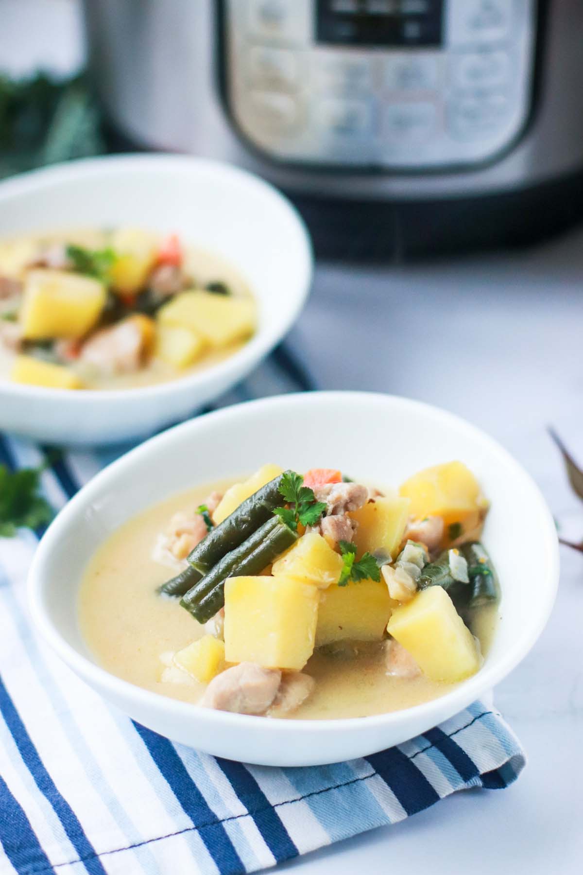 two bowls on chicken pot pie soup in from of the Instant Pot.