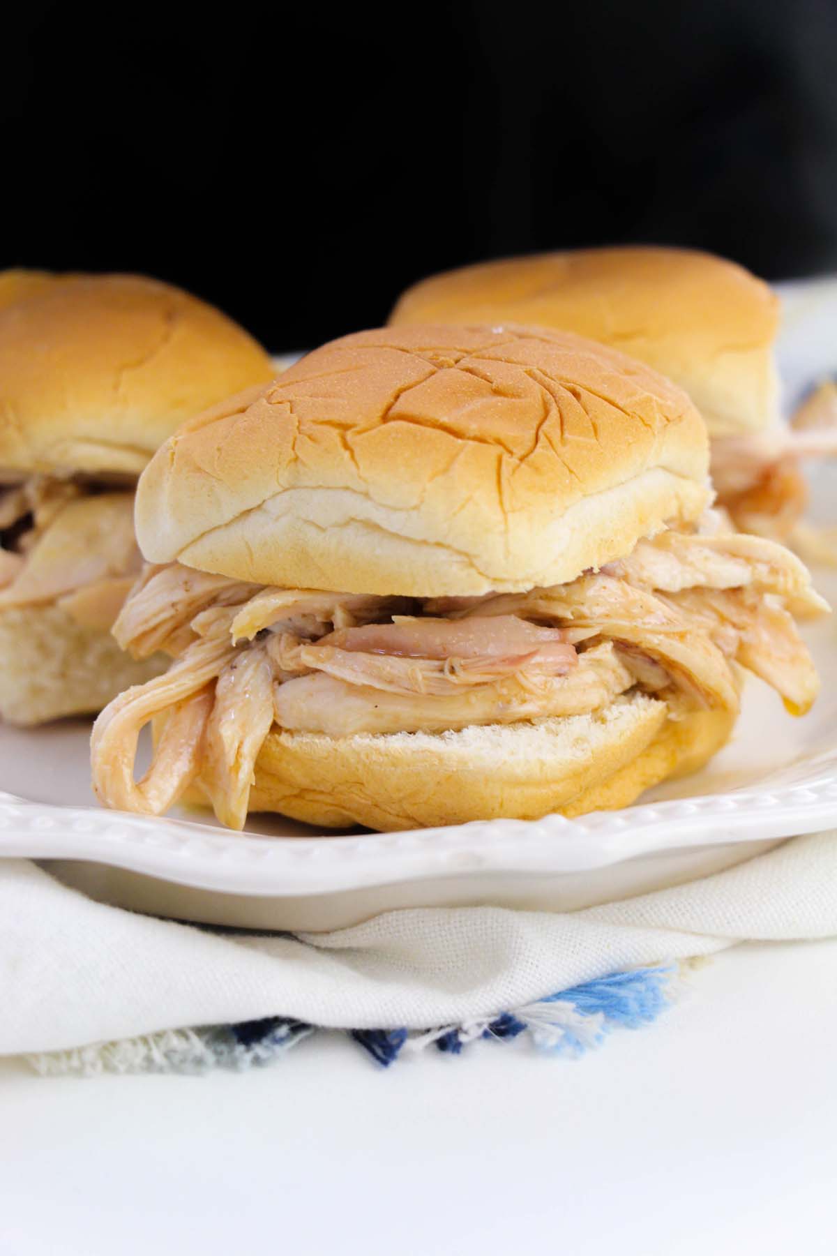Shredded chicken sandwiches on a plate.