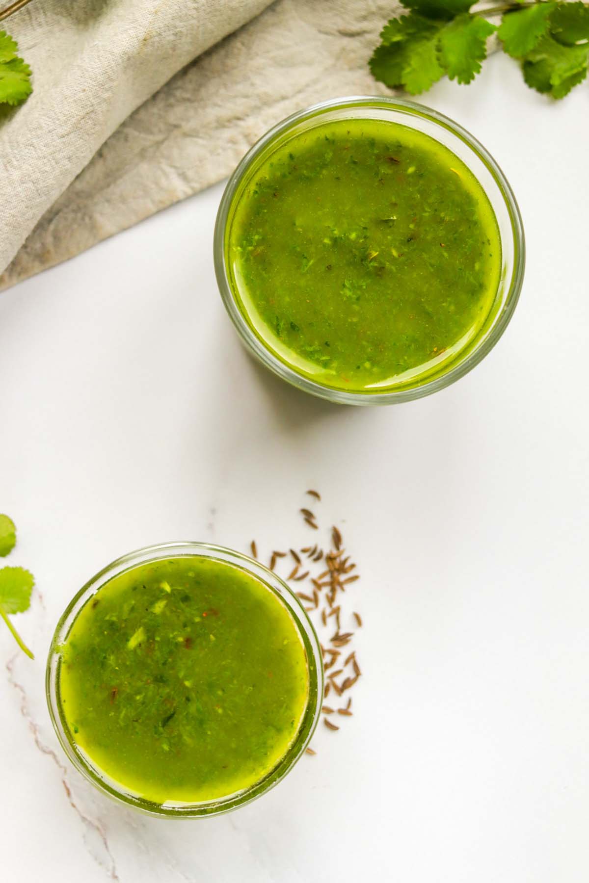 Two jars full of chimichurri sauce.