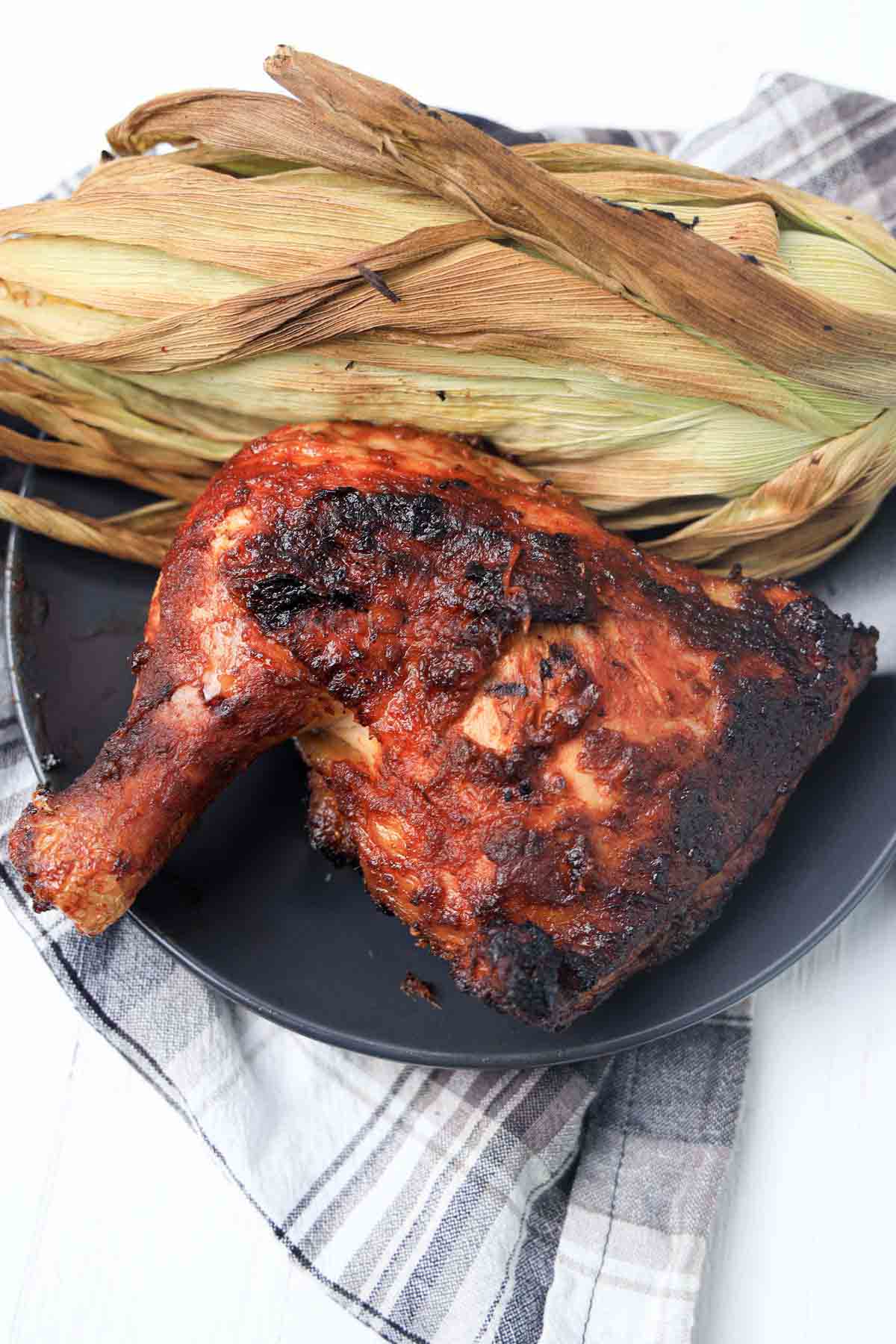 Bbq chicken on a black plate.