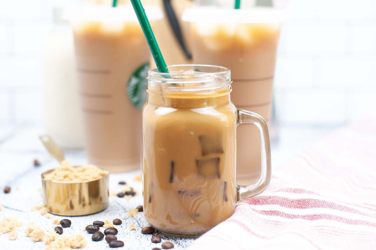 Iced espresso in a glass with a green straw.