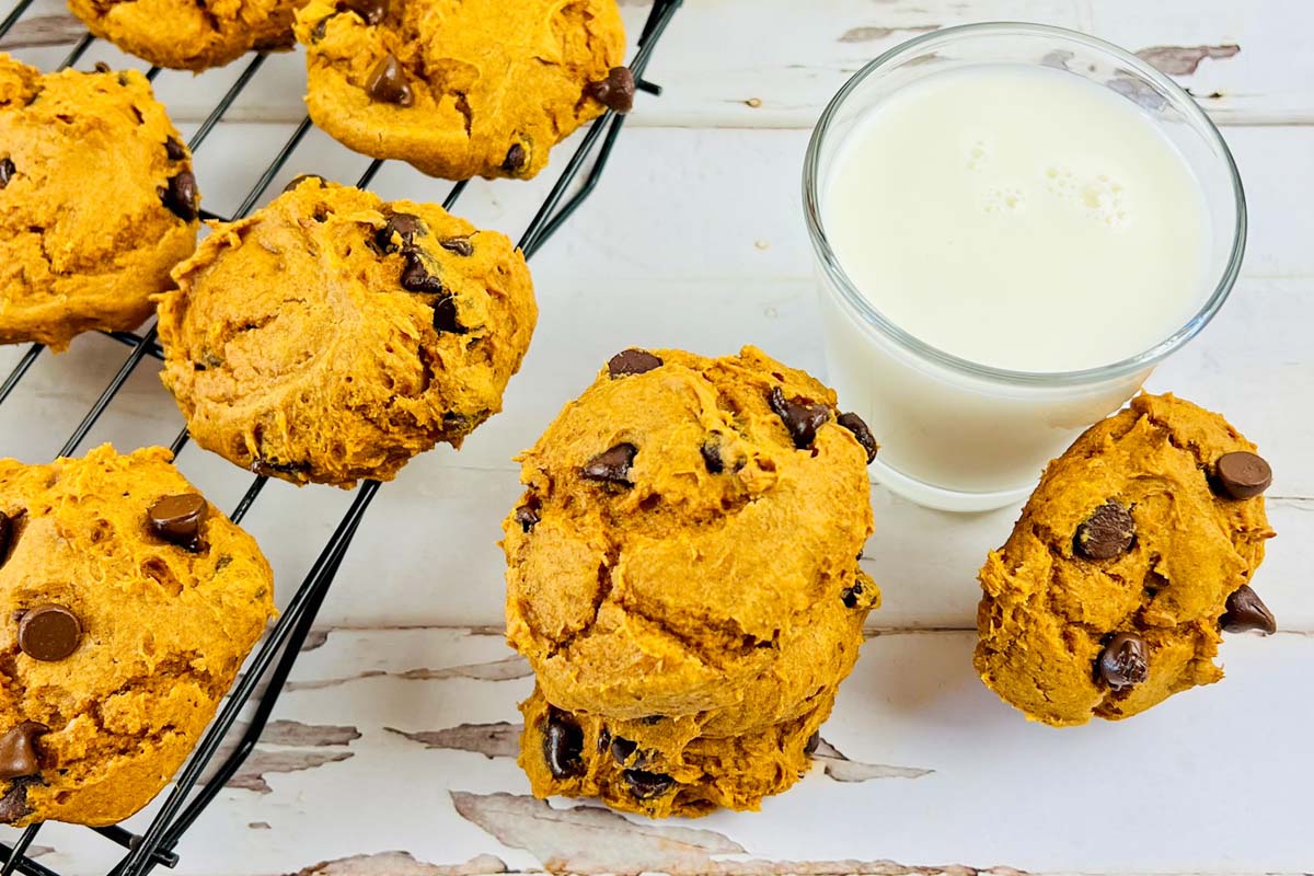 Stack of cookies next to a glass of milk.