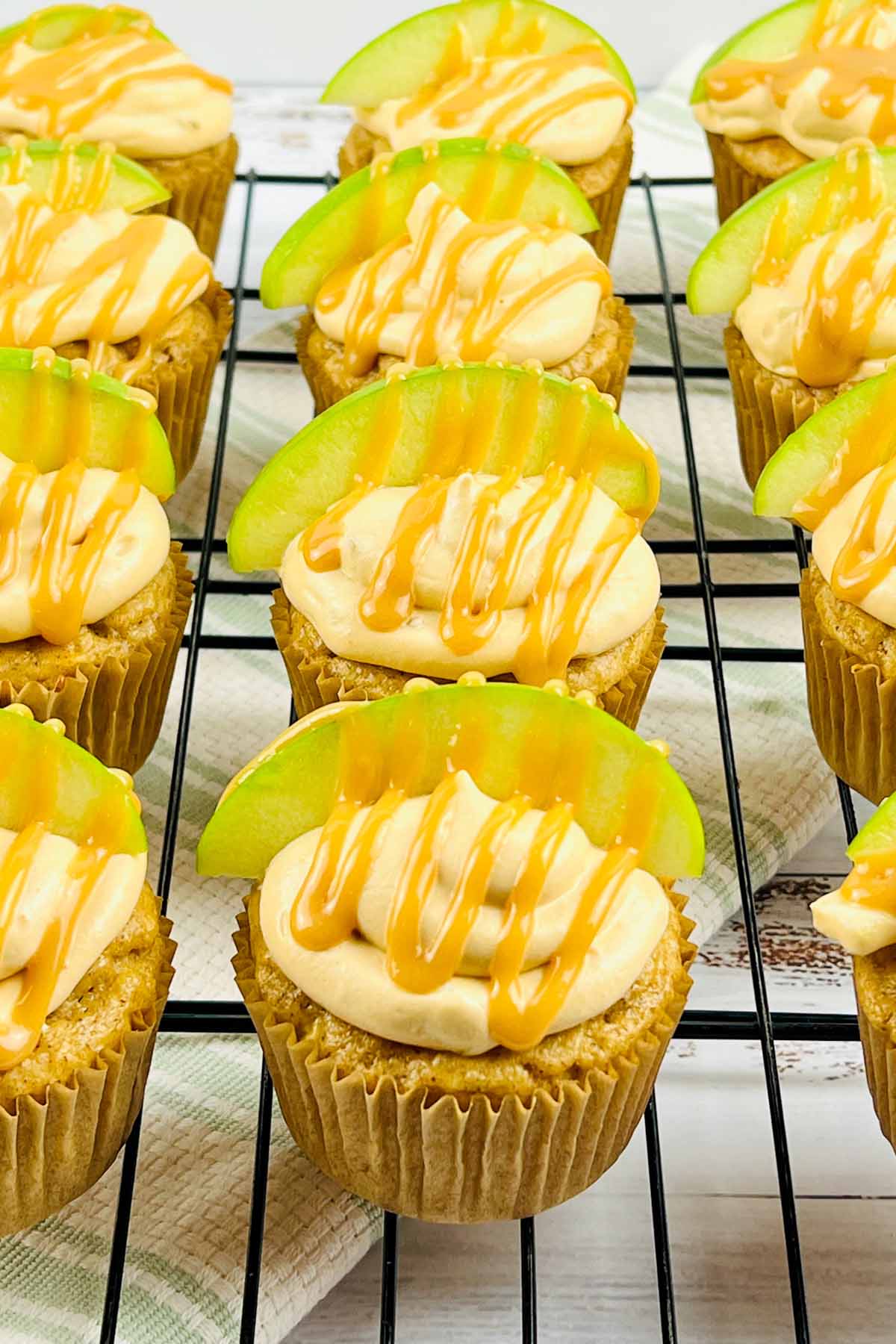 Caramel apple cupcakes on a cooling rack.