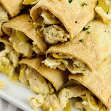 side view of taquitos on a plate.