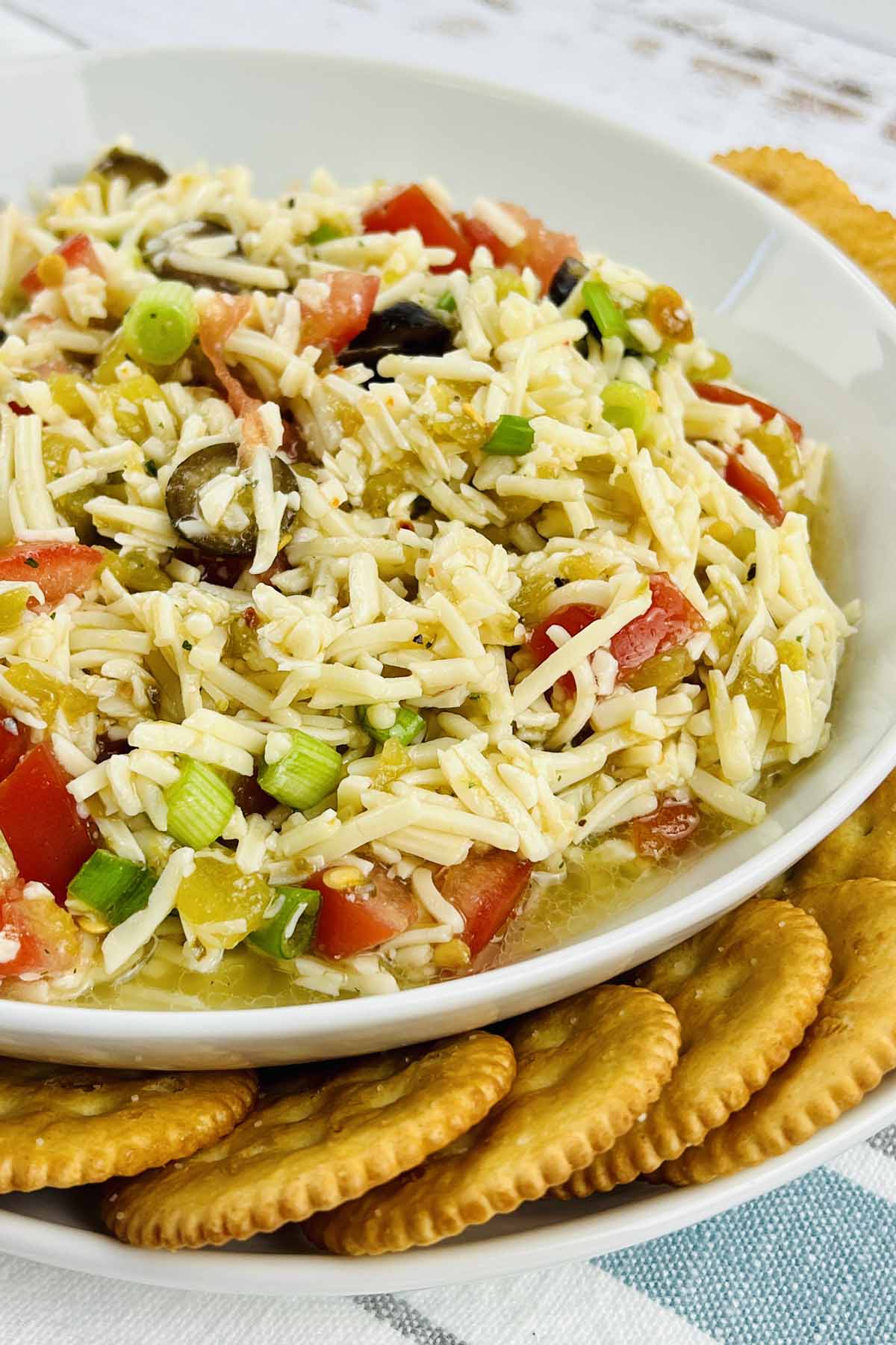 Cheese dip in a bowl with crackers on the side.