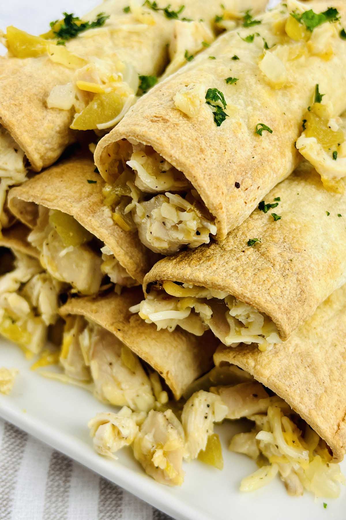 Taquitos on a white plate.