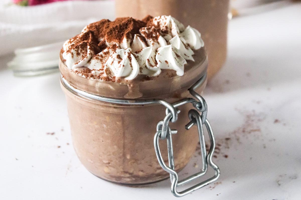 Oats in a jar topped with whipped cream.