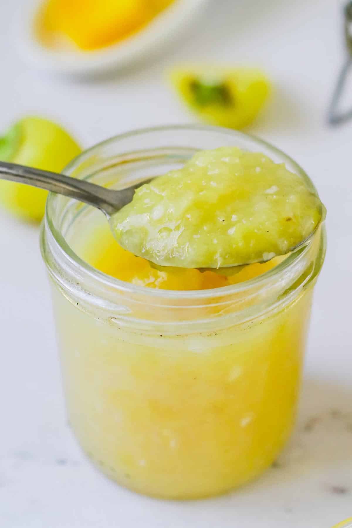 Sauce in a jar with a spoon resting on top.