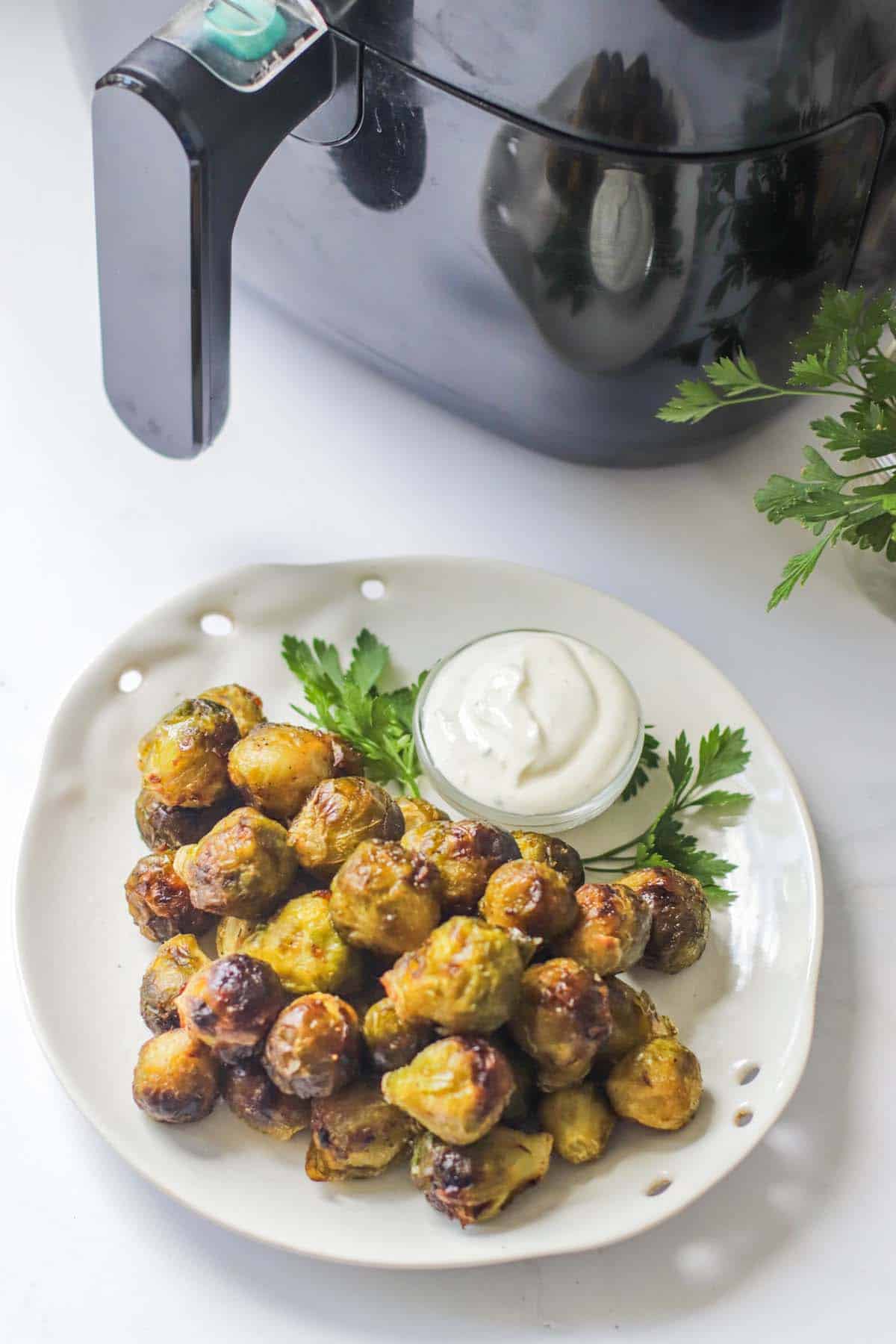 Brussels sprouts on a plate with dipping sauce.