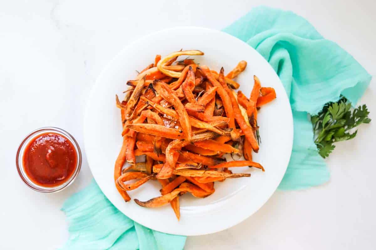 Cooked sweet potato fries on a white plate.