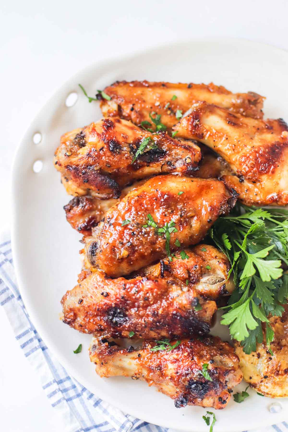 Wings on a plate topped with fresh parsley.