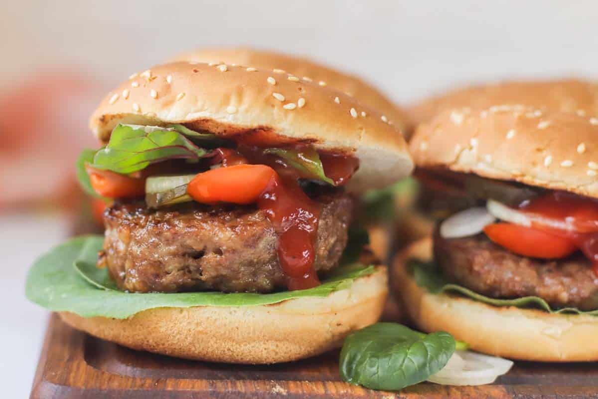 Turkey burgers on a wood platter.