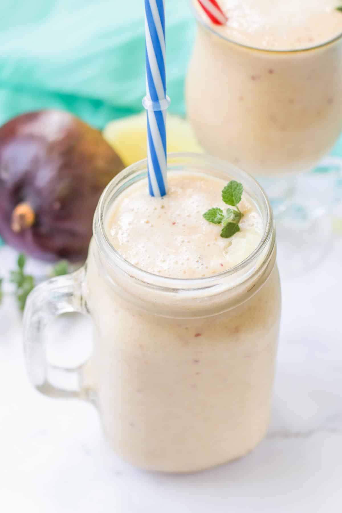 Smoothie in a glass jar with a blue straw.