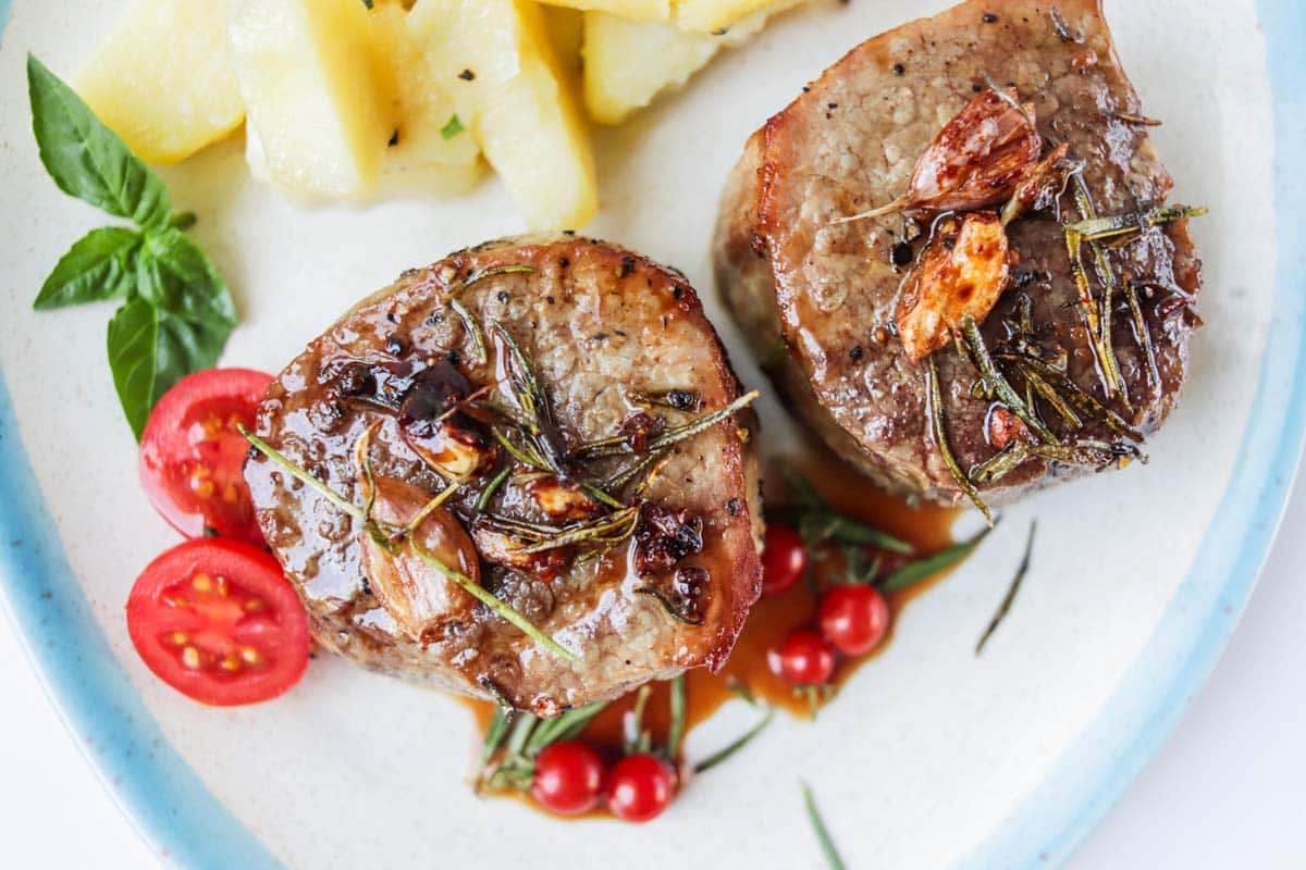 Two filet mignon steaks on a plate.