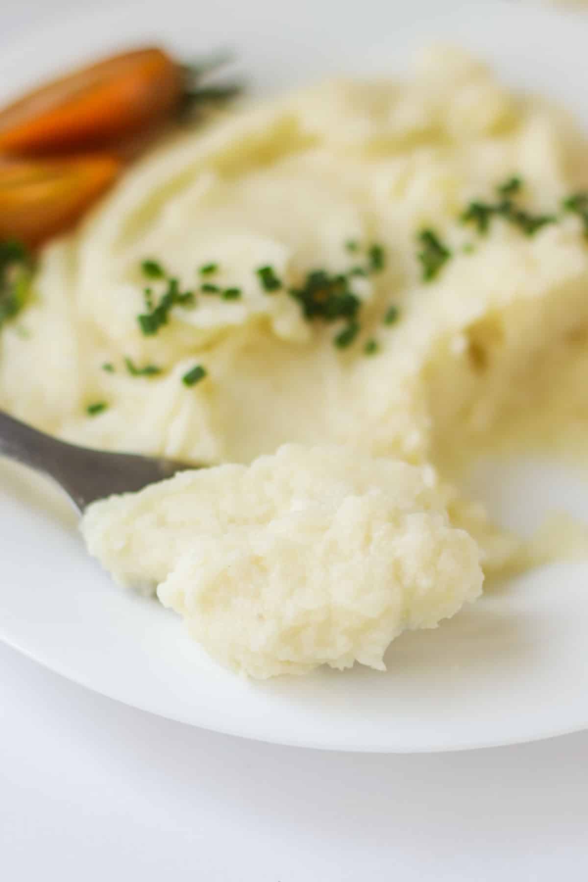 A scoop of potatoes on a spoon.