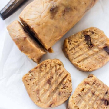 A roll of cookie dough with some slices.