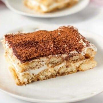 Two plates with a slice of tiramisu on each plate.