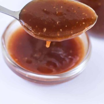 Sauce on a spoon dripping into a bowl.