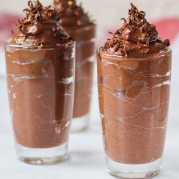 Chocolate mousse in glasses topped with shaved chocolate.