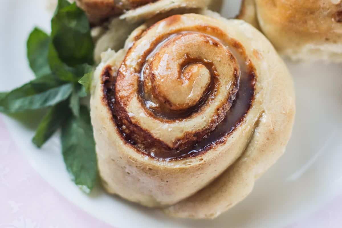 A cinnamon roll on a white plate.