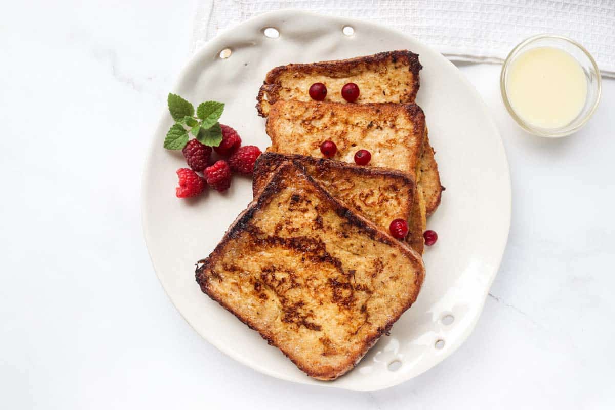 Four slices of French toast on a white plate.