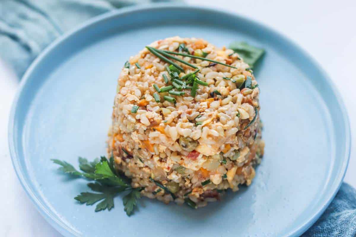 A shaped cup of rice on a plate.