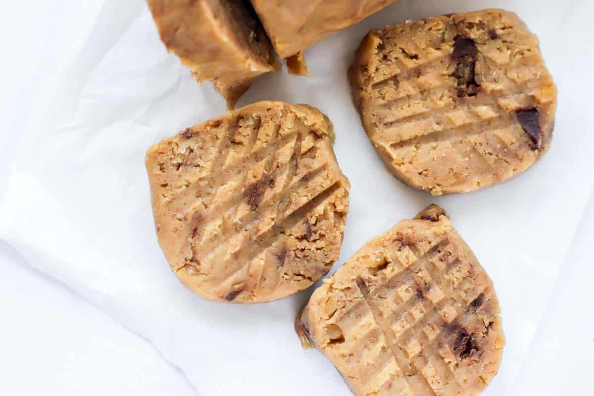 Three slices of cookie dough on parchment paper.