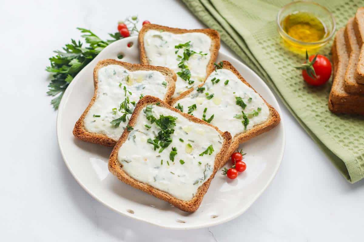 Four slices of garlic bread on a white plate.
